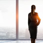 woman looking out the window in an office building