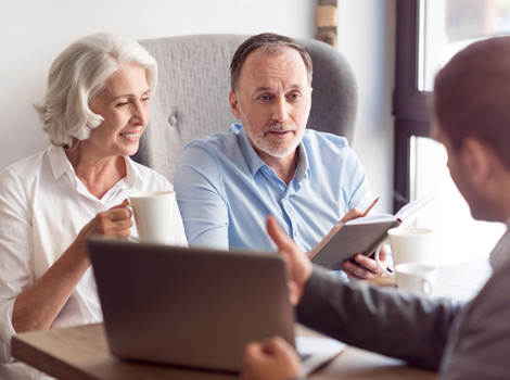 Modern Woodmen financial representative talking to a couple nearing retirement about a plan in place that would allow them to retire and continue their way of life.
