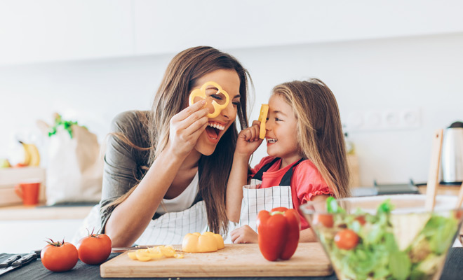 Mother and daughter working in a kitchen and having fun time together.
