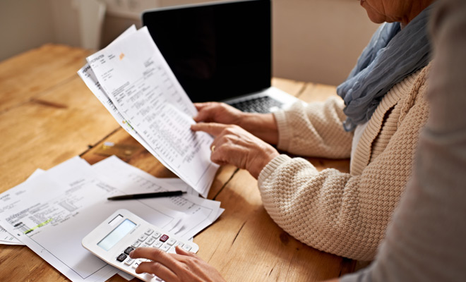 Elderly couple looking at monthly utility bill.