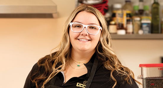 Modern Woodmen member Ashleigh posing at a kitchen counter.