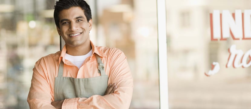 Middle age man working in the cafeteria, smiling and looking at the camera.